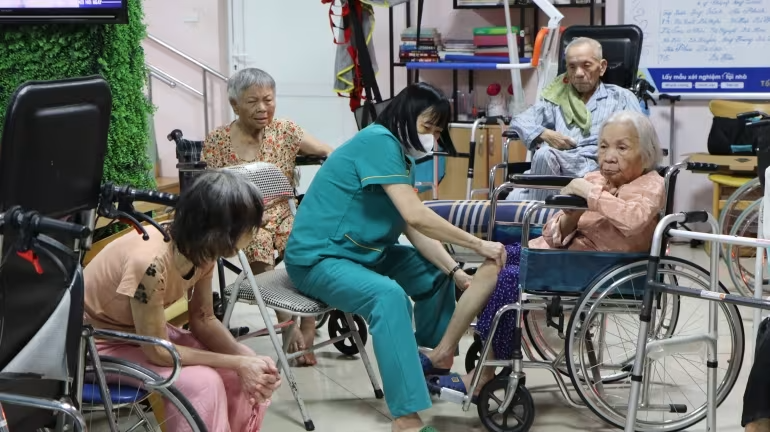 Nhân viên chăm sóc phục hồi chức năng cho người cao tuổi tại dưỡng lão Diên Hồng